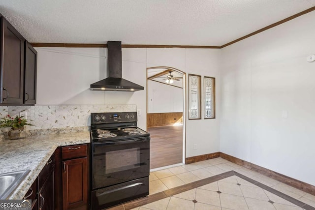 kitchen featuring dark brown cabinetry, wall chimney exhaust hood, a textured ceiling, and electric range