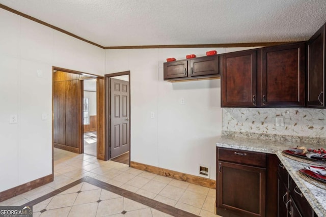 kitchen with tasteful backsplash, light tile patterned floors, light stone countertops, and a textured ceiling