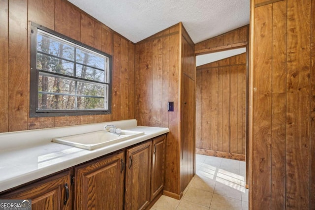 bathroom with vanity, tile patterned floors, a textured ceiling, and wood walls