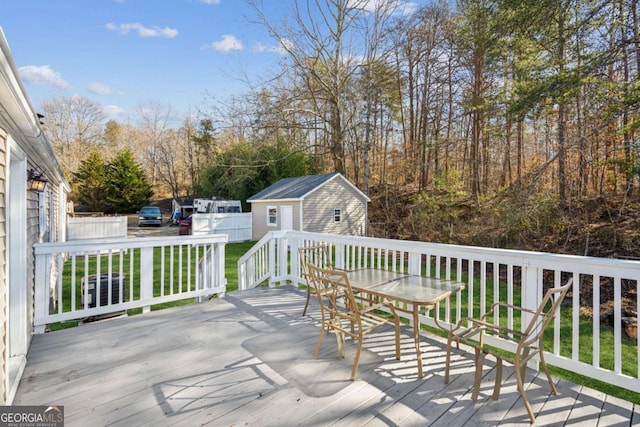 wooden deck featuring an outbuilding and a yard