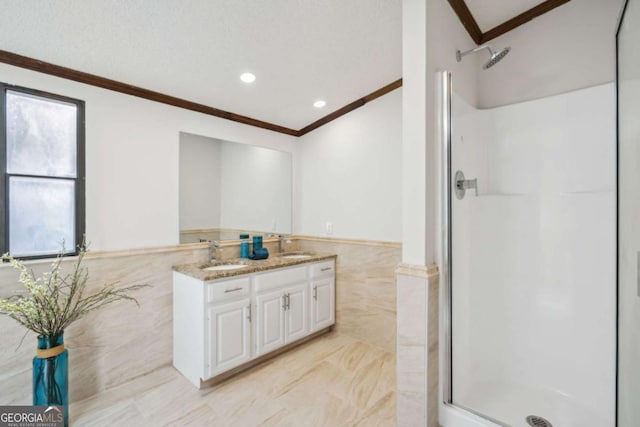 bathroom featuring a textured ceiling, tile walls, ornamental molding, vanity, and a shower with door