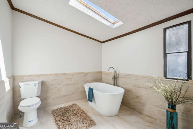 bathroom featuring toilet, ornamental molding, a bath, and a textured ceiling