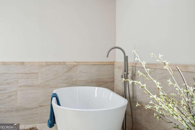 bathroom with sink, a bath, and tile walls