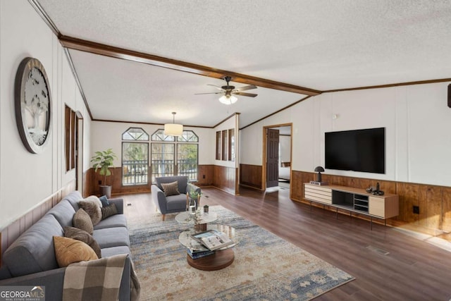 living room featuring ornamental molding, dark hardwood / wood-style flooring, a textured ceiling, and vaulted ceiling with beams