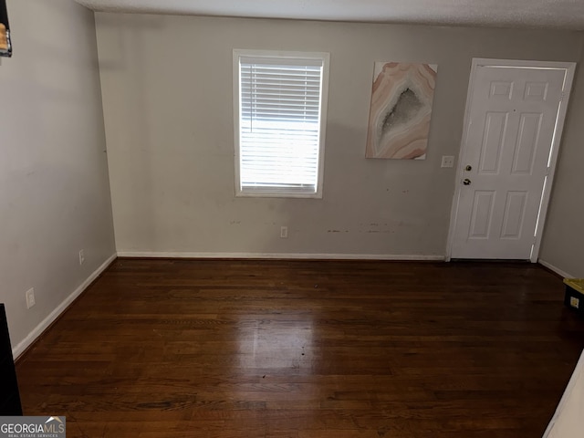 empty room featuring dark hardwood / wood-style flooring