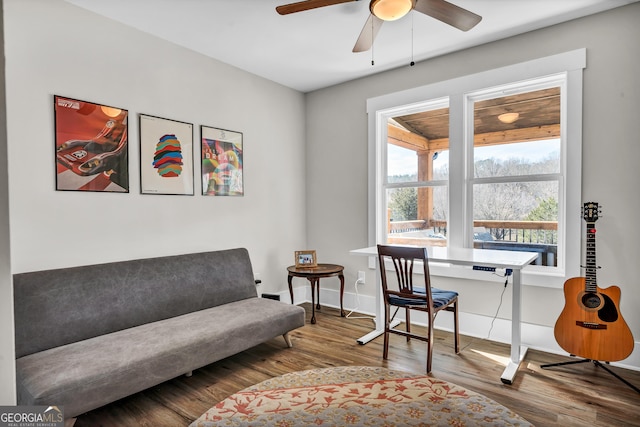 living area with wood-type flooring and ceiling fan