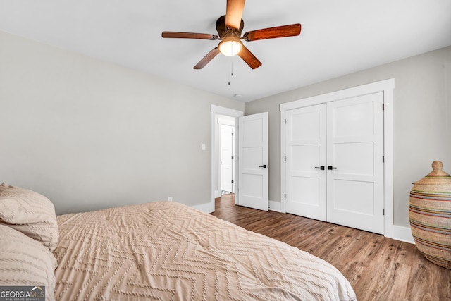 bedroom featuring wood-type flooring, ceiling fan, and a closet