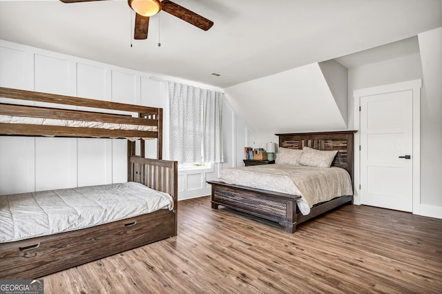 bedroom with ceiling fan, wood-type flooring, and vaulted ceiling