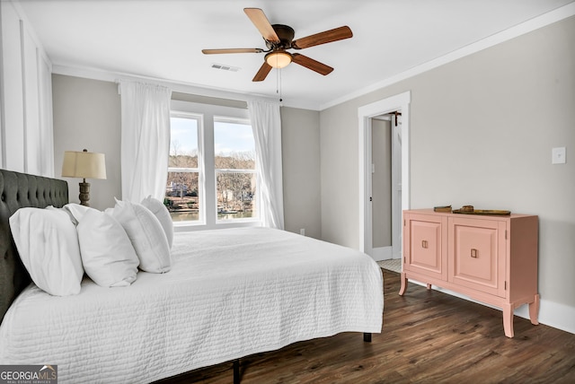 bedroom featuring ornamental molding, dark hardwood / wood-style floors, and ceiling fan