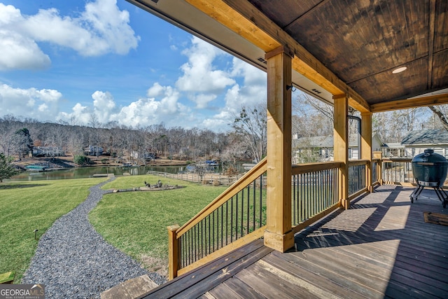 wooden deck featuring a water view and a yard