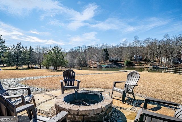 view of patio with a water view and an outdoor fire pit