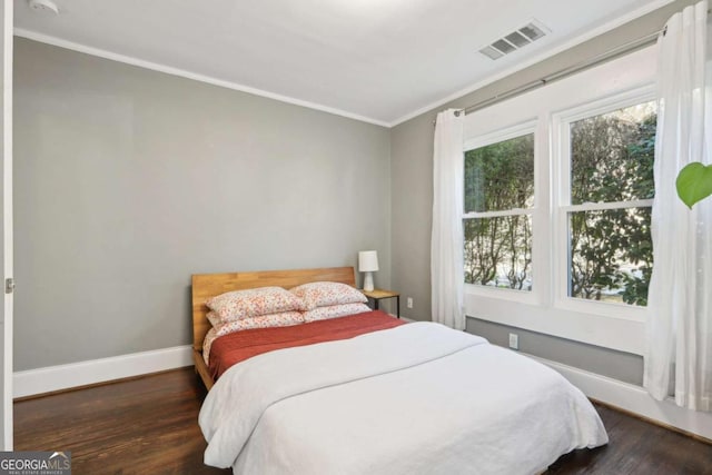 bedroom featuring ornamental molding and dark wood-type flooring