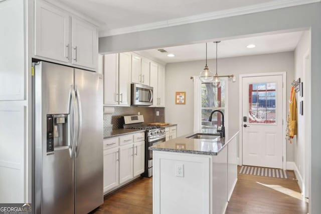 kitchen with sink, stainless steel appliances, an island with sink, and white cabinets