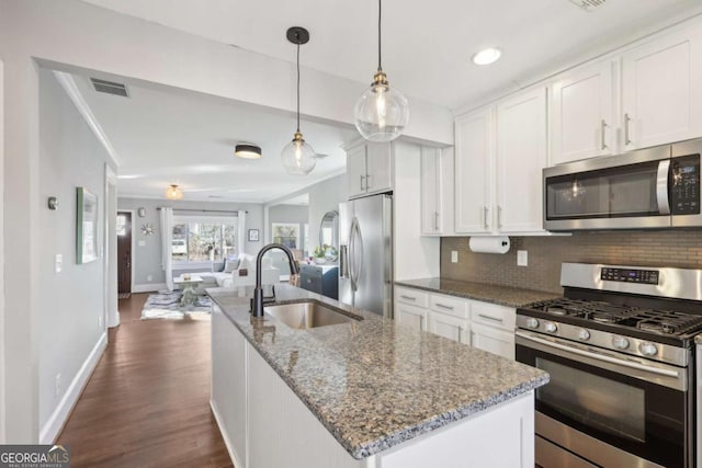 kitchen featuring sink, white cabinetry, a center island with sink, stainless steel appliances, and stone countertops