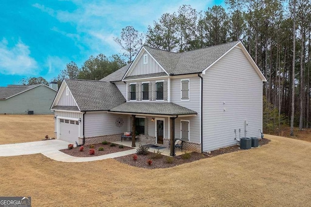 view of front facade featuring a front yard, a garage, and a porch