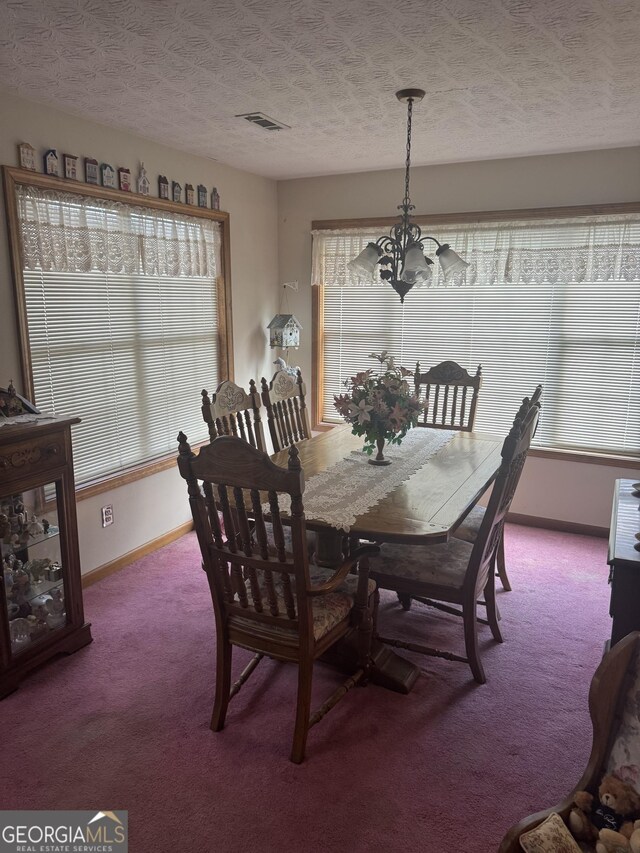 dining space with carpet, a chandelier, and a textured ceiling