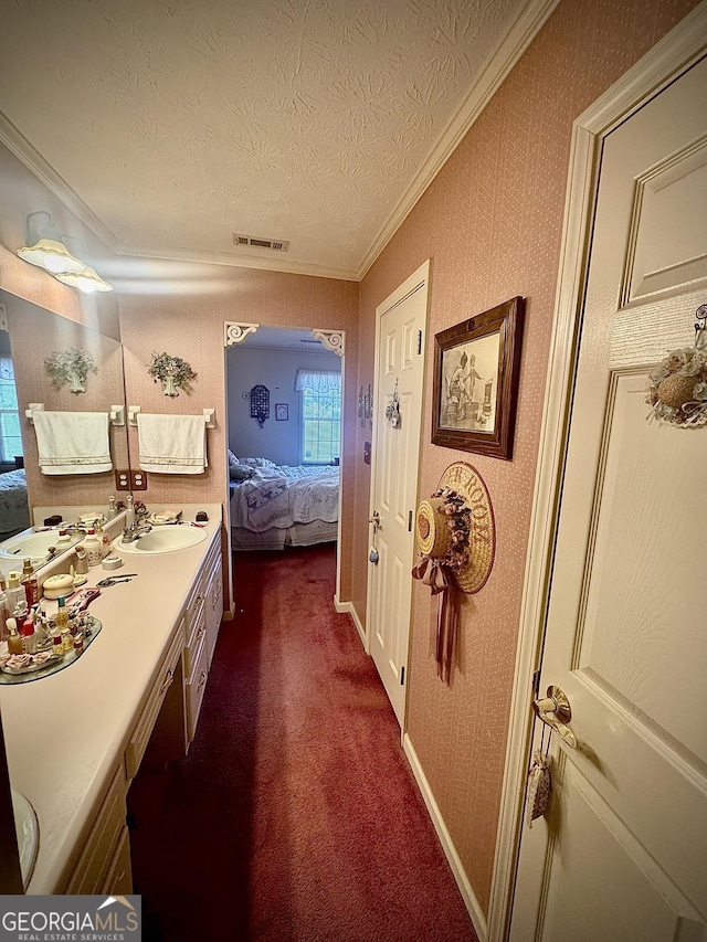 bathroom with crown molding, vanity, and a textured ceiling