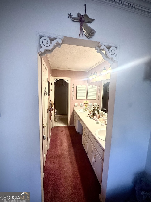 bathroom featuring vanity, crown molding, and a textured ceiling