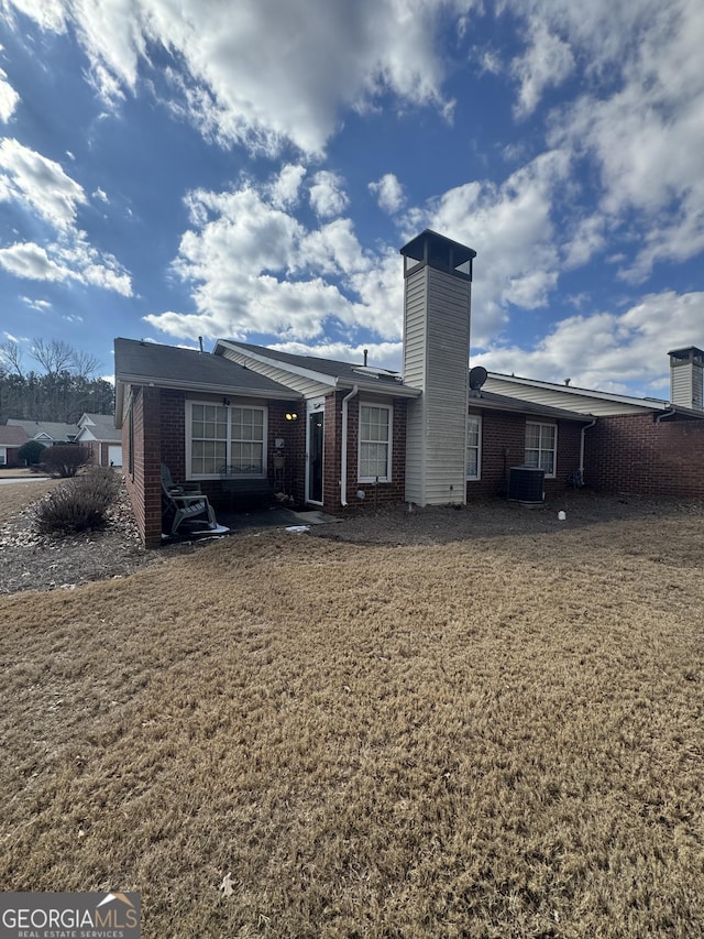 back of house with cooling unit and a yard