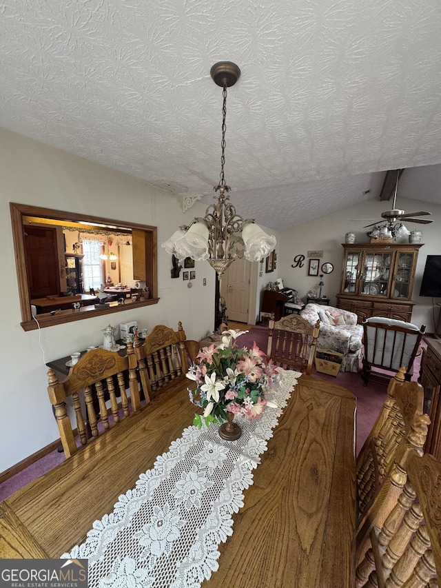 dining room featuring lofted ceiling, ceiling fan with notable chandelier, and a textured ceiling