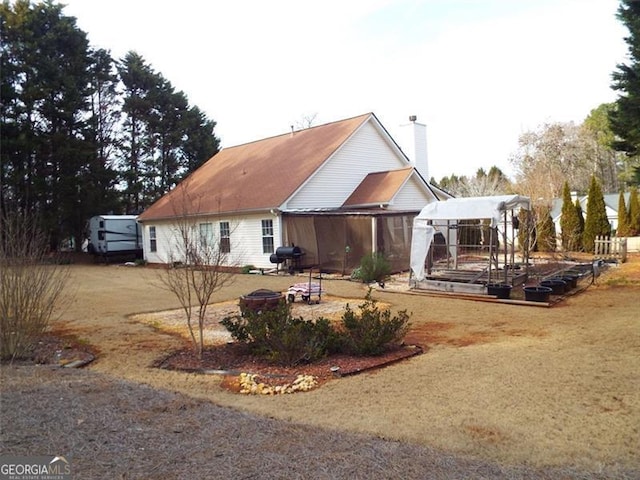 rear view of house featuring an outdoor fire pit