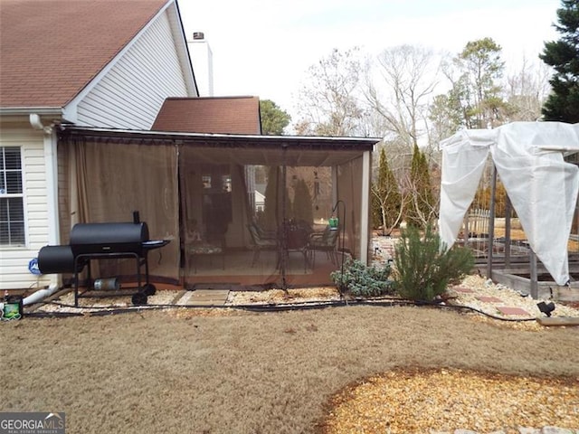 exterior space with a sunroom and a lawn