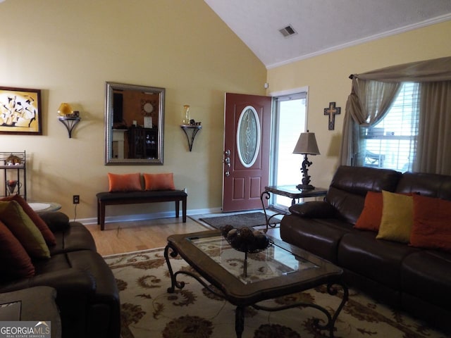 living room featuring light hardwood / wood-style flooring, vaulted ceiling, and ornamental molding