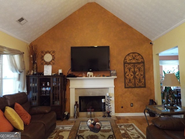 living room featuring crown molding, high vaulted ceiling, and light wood-type flooring