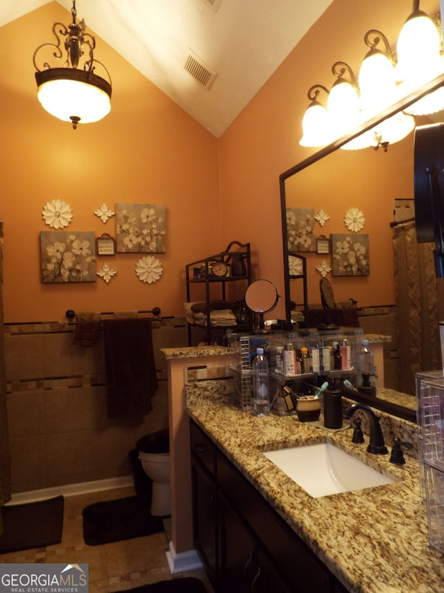 bathroom featuring lofted ceiling, toilet, tile patterned flooring, and vanity