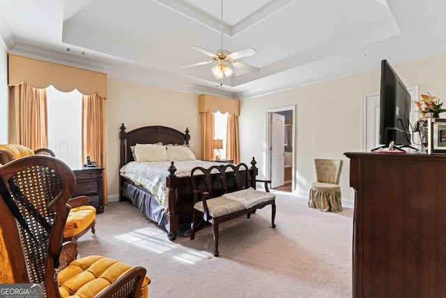 carpeted bedroom with ornamental molding, ceiling fan, and a tray ceiling