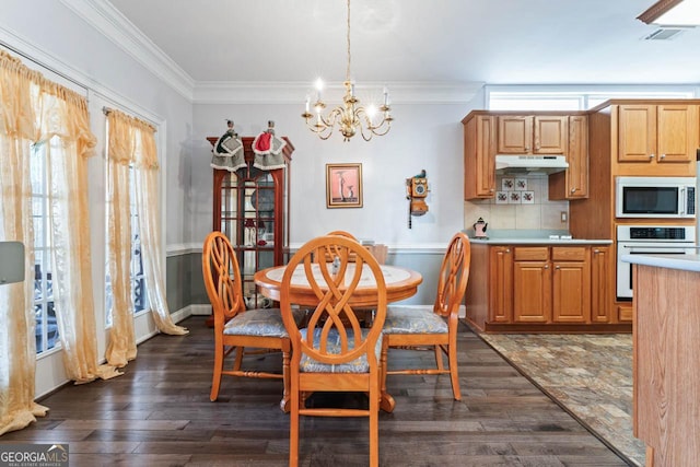 dining room featuring crown molding, dark hardwood / wood-style floors, and a notable chandelier