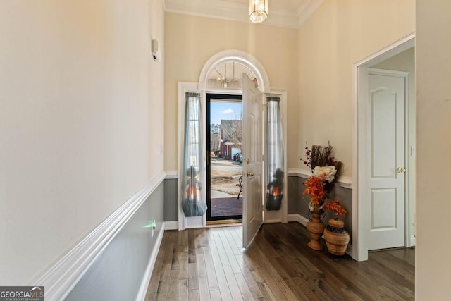 foyer with dark wood-type flooring and ornamental molding