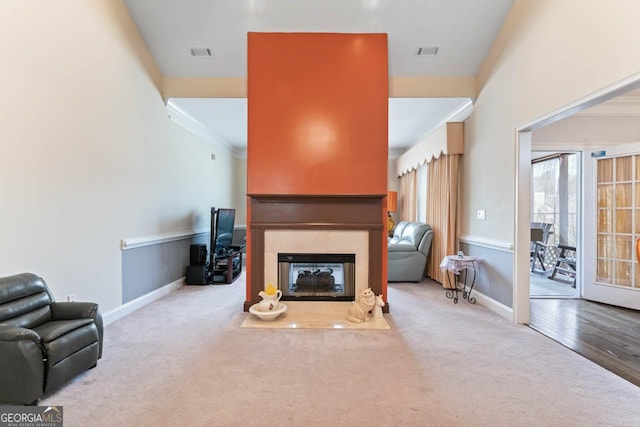 carpeted living room featuring a multi sided fireplace and crown molding