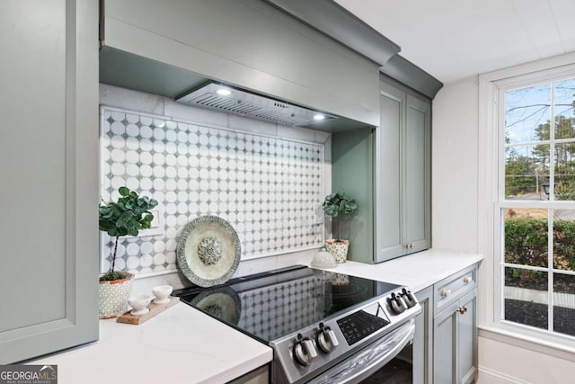 kitchen featuring gray cabinets, custom range hood, light stone counters, and electric stove