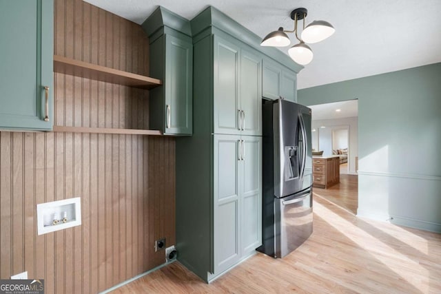 kitchen with stainless steel fridge with ice dispenser, green cabinets, hanging light fixtures, and light wood-type flooring