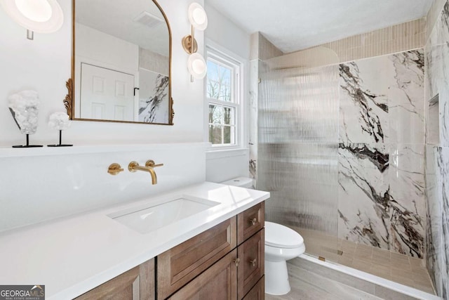 bathroom featuring vanity, toilet, and tiled shower