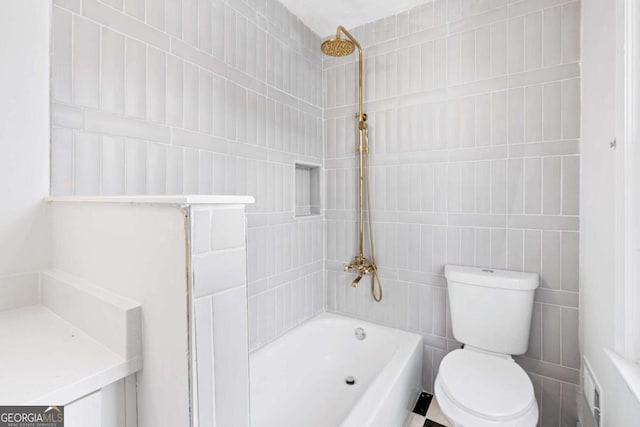 bathroom featuring tiled shower / bath combo and toilet