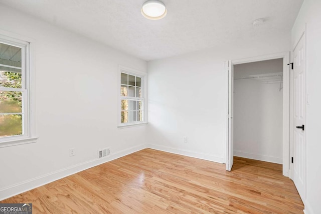 unfurnished bedroom with light hardwood / wood-style floors and a closet