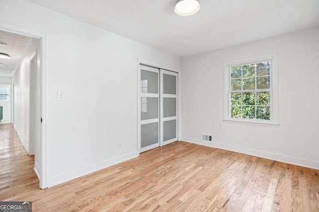 unfurnished room with light wood-type flooring