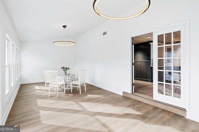 unfurnished dining area with lofted ceiling and hardwood / wood-style floors