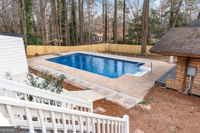 view of pool with a diving board and a patio area