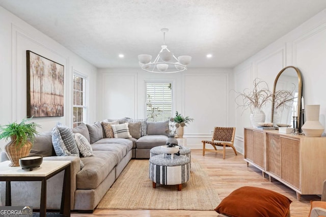 living room featuring a notable chandelier and light hardwood / wood-style flooring