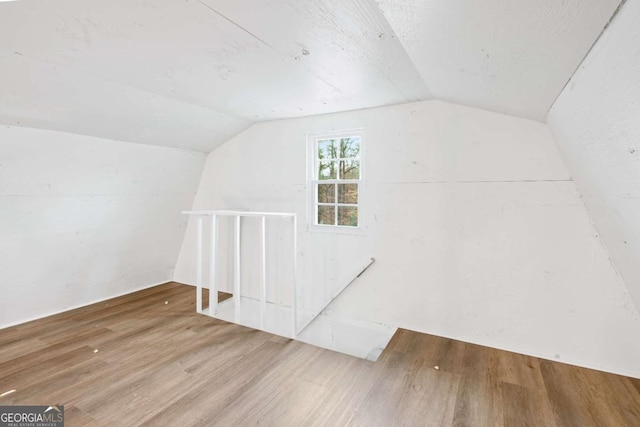 additional living space featuring hardwood / wood-style floors and vaulted ceiling