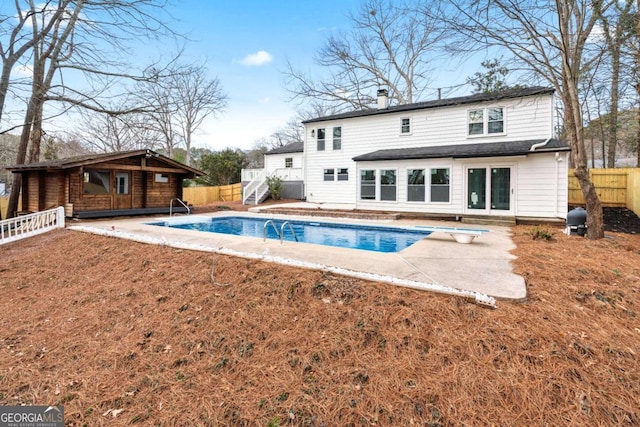 back of house with a fenced in pool, a lawn, and a patio