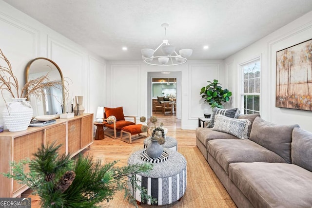 living room with an inviting chandelier and light hardwood / wood-style flooring