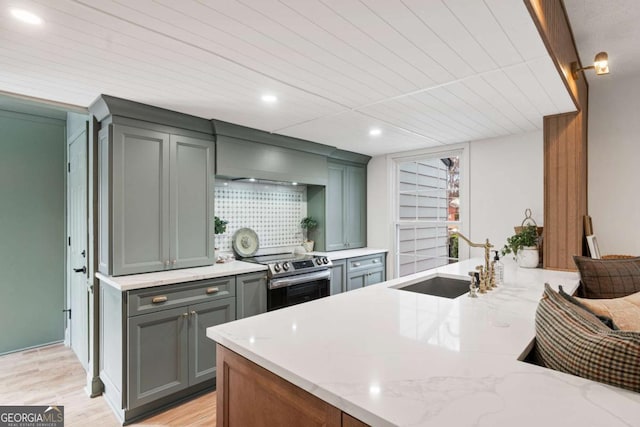 kitchen featuring sink, backsplash, electric range, light stone counters, and light wood-type flooring