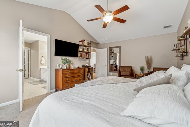 carpeted bedroom with ceiling fan, vaulted ceiling, and ensuite bath