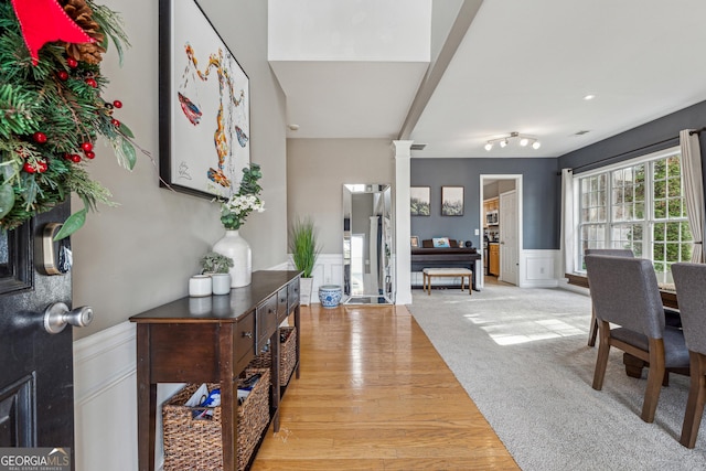 foyer entrance with decorative columns and light carpet