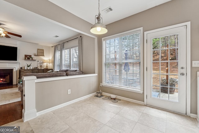 unfurnished dining area with light tile patterned flooring and ceiling fan