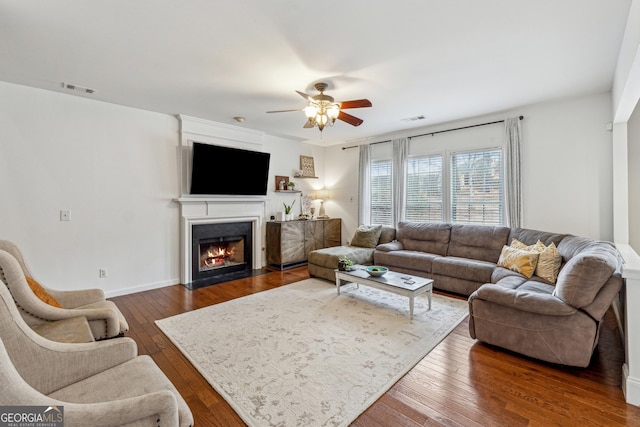 living room featuring ceiling fan and dark hardwood / wood-style flooring